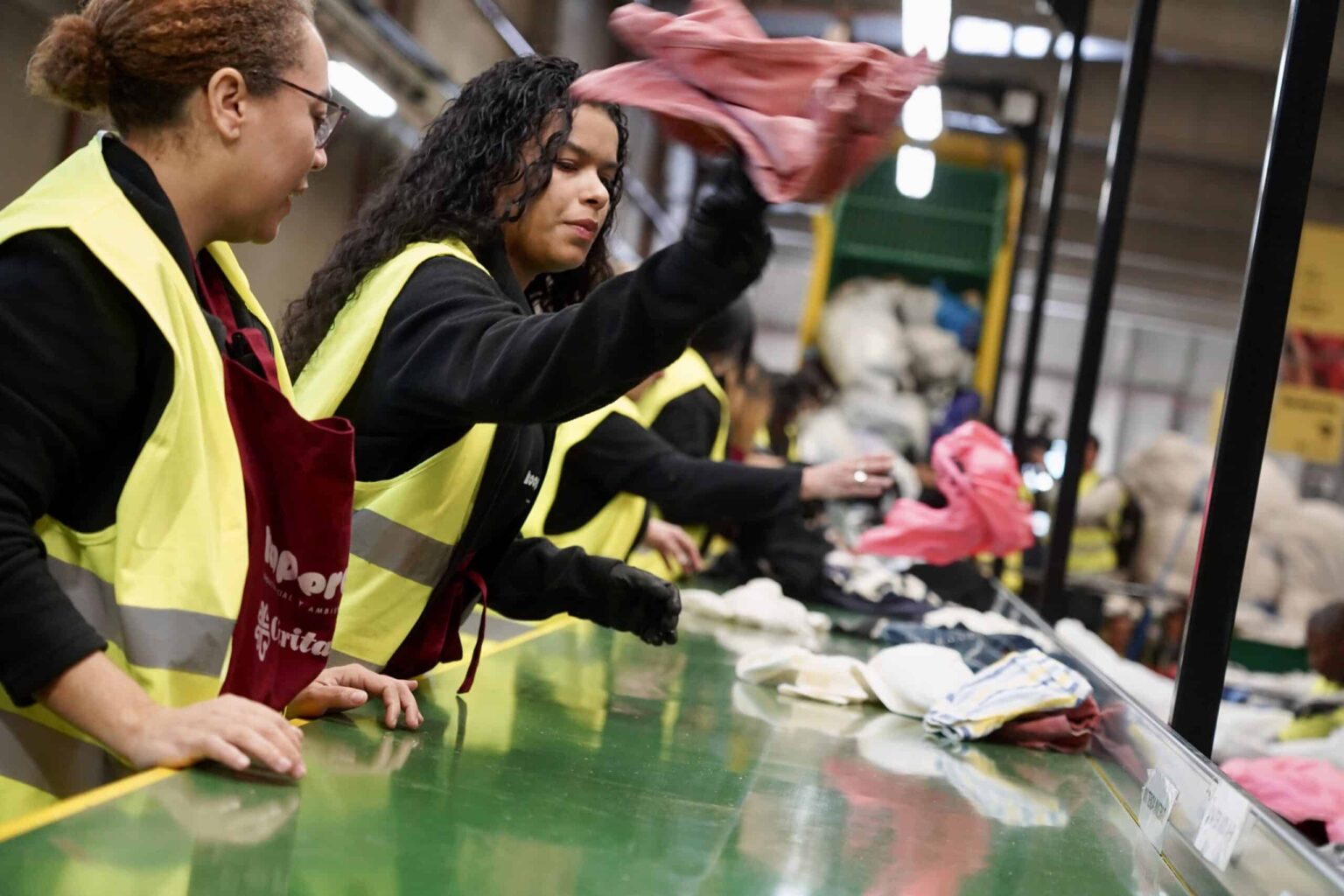 Varias mujeres de Cáritas trabajando en una cadena de producción.